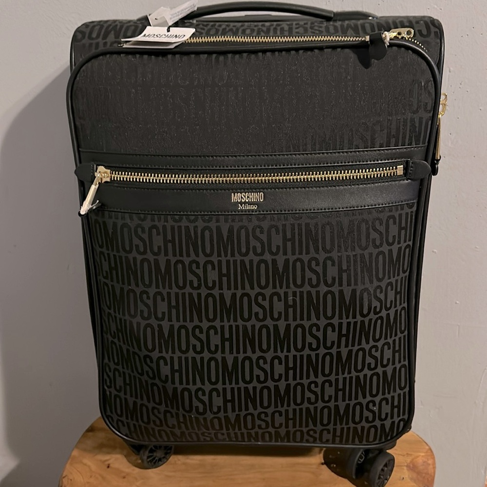 Moschino 18 inch trolley luggage with logo printed all over its luggage